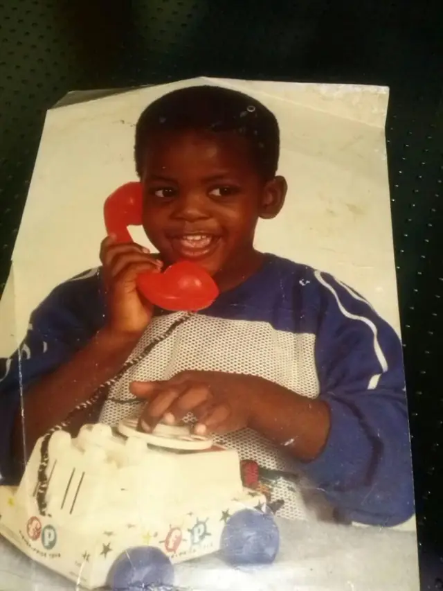 Vincent als kind met een rode speelgoedtelefoon